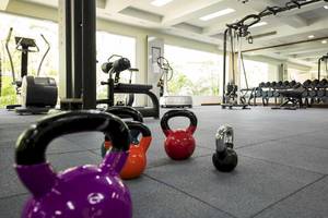 Fitnessstudio im Robinson Khao Lak Hotel mit Gewichten und Trainingsgeräten.
