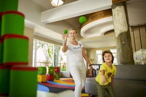 Eine Frau und ein Kind spielen im Innenbereich des Robinson Khao Lak Hotels.