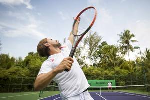 Tennisspieler im Robinson Khao Lak Hotel, der einen Ball schlägt.