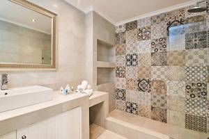 Badezimmer von Agali Houses mit einer Badewanne, einem Waschbecken und gefliesten Wänden