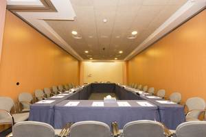 Ein Konferenzraum im Gloria Palace Amadores Thalasso & Hotel mit langen Tischen und Stühlen.