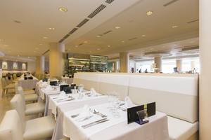 Innenansicht des Restaurants im Gloria Palace Amadores Thalasso & Hotel mit eleganten Tischen und Stühlen.