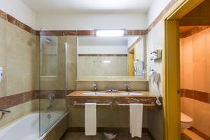 Ein Badezimmer mit zwei Waschbecken, einer Badewanne und einer Duschkabine.