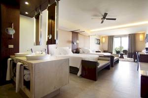 Innenansicht der Suite im Barcelo Bavaro Palace Hotel mit Doppelbetten, Badezimmer und Wohnzimmerbereich.