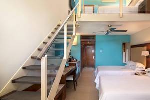Hotelzimmer im Barcelo Bavaro Palace mit zwei Betten und einer Zwischenebene.
