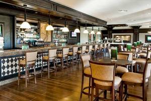 Innenansicht der Bar des Barcelo Bavaro Palace Hotels mit Holzboden und Stühlen.