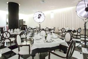 Restaurant des Barcelo Bavaro Palace mit schwarzem und weißem Schachbrettboden und weißen Tischen.