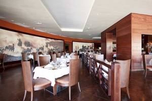 Innenansicht des Restaurants im Barcelo Bavaro Palace Hotel mit gedeckten Tischen und Holzelementen.