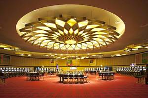 Casino im Barcelo Bavaro Palace mit großen Tischen und Spielautomaten.