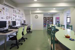 Innenansicht des Kinderzimmers im Creta Maris Resort mit Computern und grünen Tischen.