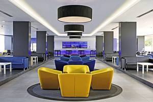 Lobby des Gran Canaria Princess Hotels mit bunten Sitzgruppen und Bar im Hintergrund.