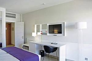Innenansicht eines Hotelzimmers im Gran Canaria Princess Hotel mit Schreibtisch, Bett und Fernseher.