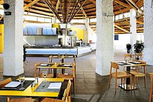 Innenansicht des Restaurants im Gran Canaria Princess Hotel mit gelben Tischen und Holzstühlen.