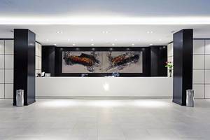 Empfangsbereich des Gran Canaria Princess Hotels mit modernem Design und großem Kunstwerk an der Wand.
