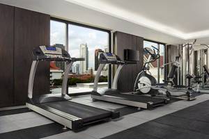 Fitnessbereich im Mövenpick Hotel Sukhumvit 15 Bangkok mit Laufbändern und anderen Geräten.