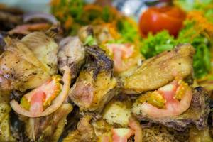 Gegrilltes Huhn mit Tomaten und Gemüse auf einem Teller