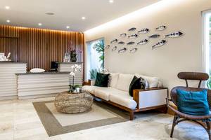 Empfangsbereich des Sunscape Coco Punta Cana Hotels mit weißem Sofa, Tisch und Dekorationen.