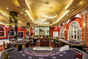 Spielbereich im Casino des Sunscape Coco Punta Cana Hotels mit Blackjack-Tischen und gedimmten Lichtern.