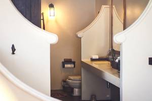 Ein Badezimmer im Saree Samui Resort mit einer Toilette, einem Waschbecken und einer Lampe.