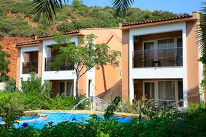 Außenansicht des Club Yali Hotels & Resort mit Swimmingpool und Gebäuden.