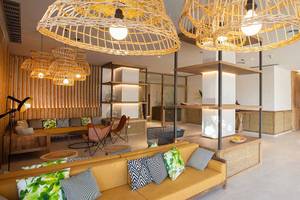 Empfangsbereich des Corallium Dunamar Garden by Lopesan Hotels mit Sofas, Lampen und Schreibtisch.