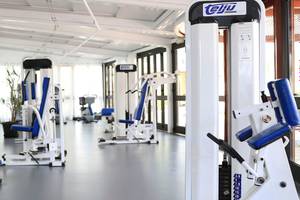 Fitnesscenter im Corallium Dunamar Garden Hotel mit verschiedenen Trainingsgeräten und Spiegeln