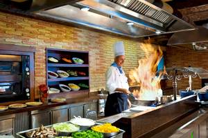 Koch im Occidental Playa de Palma Hotel mit Flammen beim Kochen in der Küche