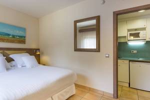 Hotelzimmer im Occidental Playa de Palma mit Bett, Spiegel und Kunstwerk an der Wand.