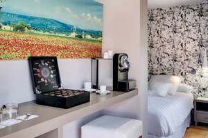 Ein elegantes Hotelzimmer im Occidental Playa de Palma mit einem Schreibtisch, einer Kaffeemaschine und einem Bett.