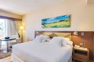 Hotelzimmer im Occidental Playa de Palma mit Bett, Tisch, Stühlen und Ausblick.