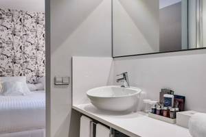 Badezimmer des Occidental Playa de Palma Hotels mit weißen Möbeln und einem Waschbecken.