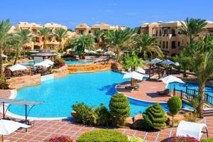 Außenbereich des Pools im Steigenberger Coraya Beach Resort mit Palmen und Liegestühlen.
