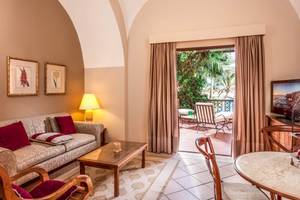 Wohnzimmer des Steigenberger Coraya Beach Hotels mit Blick auf eine Terrasse und einen Garten.