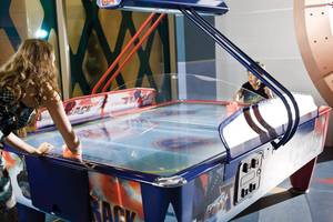 Zwei Personen spielen Air Hockey im Cornelia Diamond Golf Resort & Spa.