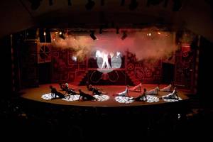 Cornelia Diamond Golf Resort & Spa Theater Aufführung mit roten Lichtern und Nebeleffekten auf der Bühne.
