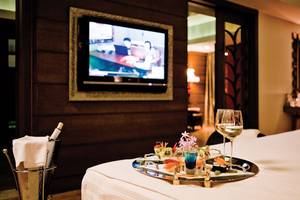 Zimmer im Cornelia Diamond Golf Resort & Spa mit Bett, Fernseher, Tisch und Getränken.