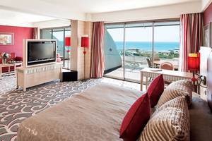 Suite Zimmer im Cornelia Diamond Golf Resort & Spa mit Meerblick, Fernseher und gemütlichem Bett.