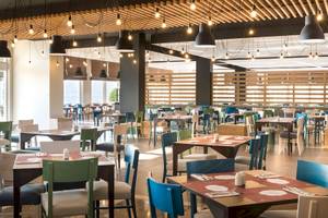 Innenansicht des Restaurants im Remisens Hotel Epidaurus mit vielen bunten Tischen und Stühlen.