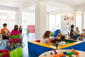 Familien und Kinder spielen in einem farbenfrohen Spielbereich im Remisens Hotel Epidaurus.