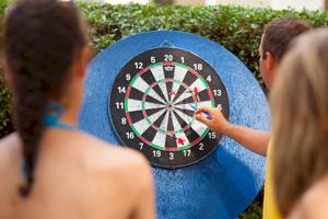 Drei Personen spielen Dart auf einem großen Zielbrett im Freien, Remisens Hotel Epidaurus