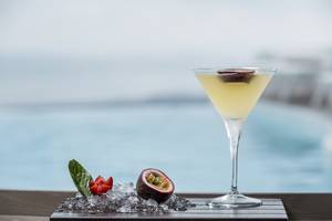 Cocktail auf einer Eisschale mit Früchten neben dem Pool im Katikies Chromata Santorini
