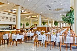 Restaurant des DIT Evrika Beach Club mit gedeckten Tischen und Blumendekor