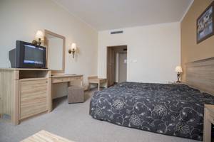 Doppelbettzimmer im DIT Evrika Beach Club Hotel mit Fernseher, Schreibtisch und Spiegel.