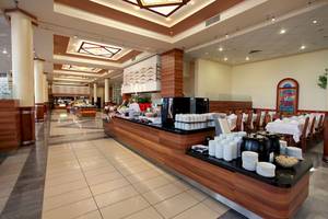 Innenbereich des DIT Evrika Beach Club Hotels mit Buffet und Sitzbereichen.