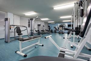 Fitnessraum im DIT Evrika Beach Club mit verschiedenen Geräten und blauen Boden
