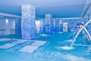 Innenpool des Alexandre Hotel Gala mit blauen Säulen und Wasserfällen.