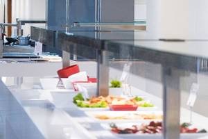 Buffet im Speisebereich des Alexandre Hotel Gala mit verschiedenen Gerichten und Salaten.