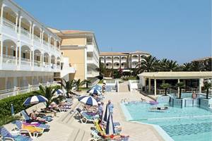 Außenbereich des Poseidon Beach Hotels mit Swimmingpool, Sonnenliegen und Sonnenschirmen.