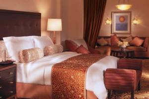 Luxuriöses Hotelzimmer im Atlantis The Palm mit Bett, Nachttischen und Wohnzimmermöbeln.