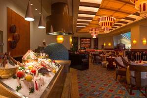 Innenansicht des Restaurants im Atlantis The Palm mit Fischbuffet, Tischen und Stühlen.